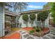 Professionally landscaped backyard with a covered patio, stone pathway, red mulch, and manicured shrubbery at 1801 Wilmore Dr, Charlotte, NC 28203