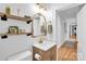 Well-lit bathroom featuring a modern vanity, decorative mirror, and open shelving at 1801 Wilmore Dr, Charlotte, NC 28203