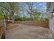 A concrete driveway is next to a wooden fence and mature trees in the backyard at 1801 Wilmore Dr, Charlotte, NC 28203
