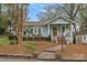 Inviting cottage-style home with brick pathway, lush landscaping, and covered front porch at 1801 Wilmore Dr, Charlotte, NC 28203