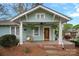 Quaint front porch with a porch swing, hanging plants, and a classic wooden door, enhancing the home's character at 1801 Wilmore Dr, Charlotte, NC 28203