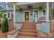 Inviting front porch with seating, hanging ferns, and decorative brick accents at 1801 Wilmore Dr, Charlotte, NC 28203