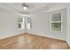 Bright bedroom features tray ceilings, wood-look flooring, and sun-filled windows at 1828 Aston Mill Pl, Charlotte, NC 28273