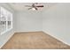 Bedroom with bright window and ceiling fan, neutral carpeting and paint at 1828 Aston Mill Pl, Charlotte, NC 28273