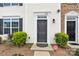 Charming townhome entrance with a gray front door, decorative plants, and classic trim at 1828 Aston Mill Pl, Charlotte, NC 28273