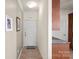 Inviting hallway with neutral walls, decorative art, tile flooring, and partial view of the kitchen at 18742 Nautical Dr # 301, Cornelius, NC 28031