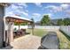 Large backyard with paver patio, gazebo with dining set, grill, and trampoline against a white fence at 190 Silverspring Pl, Mooresville, NC 28117
