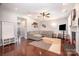 Open-concept living room with hardwood floors, a cozy fireplace, and a sectional sofa at 190 Silverspring Pl, Mooresville, NC 28117
