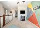 Spacious play room featuring colorful geometric wall, flat screen television and open access to adjacent bedrooms at 190 Silverspring Pl, Mooresville, NC 28117