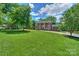 Beautifully landscaped front yard with a classic brick home featuring a charming covered porch at 203 Mt Holly Huntersville Rd, Huntersville, NC 28078
