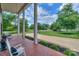 Spacious front porch with brick flooring and pillars, offering scenic views of the landscaped yard at 203 Mt Holly Huntersville Rd, Huntersville, NC 28078
