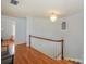 A well-lit hallway with hardwood floors and a staircase at 203 Mt Holly Huntersville Rd, Huntersville, NC 28078