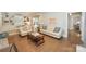 Bright and airy living room featuring hardwood floors, neutral decor, and ample natural light at 203 Mt Holly Huntersville Rd, Huntersville, NC 28078