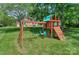 Outdoor playset including swings, climbing wall, and slide, surrounded by lush greenery, perfect for Gathering fun at 203 Mt Holly Huntersville Rd, Huntersville, NC 28078