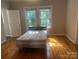 Sunlit bedroom with hardwood floors, a comfortable bed, and natural light at 211 W 2Nd St, Kershaw, SC 29067