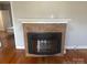 A brick fireplace is the centerpiece of this room with hardwood floors and neutral walls at 211 W 2Nd St, Kershaw, SC 29067