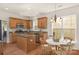 Open kitchen with an island, wood cabinets, stainless steel appliances, and adjacent breakfast area at 2136 Ashley River Rd, Waxhaw, NC 28173