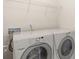 A laundry room with white washer and dryer under wire shelving at 2136 Ashley River Rd, Waxhaw, NC 28173