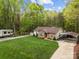 Aerial view of a charming single-story home surrounded by lush trees and a well-manicured lawn at 214 Creek View Rd, Mooresville, NC 28117
