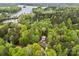 Picturesque aerial view of a wooded property with a house, garage, and lake in the background at 214 Creek View Rd, Mooresville, NC 28117