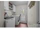 Laundry room with white washer and dryer units and overhead storage cabinets at 214 Creek View Rd, Mooresville, NC 28117