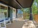 Covered back deck with rocking chairs and gray curtains, a perfect outdoor retreat at 2234 Emerald Mine Rd, Shelby, NC 28152