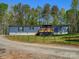Blue single-story home featuring a wooden deck, dark trim, and surrounded by a green lawn and trees at 2234 Emerald Mine Rd, Shelby, NC 28152