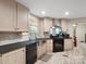Well-lit kitchen with light wood cabinets, stainless steel sink, and black appliances at 2234 Emerald Mine Rd, Shelby, NC 28152