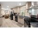 Open kitchen view with black appliances, light wood cabinets, and adjacent living space at 2234 Emerald Mine Rd, Shelby, NC 28152