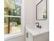 Bright bathroom featuring a modern vanity with a white countertop and black fixtures, complemented by a square mirror at 2512 Remington St, Charlotte, NC 28216