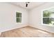 Bright bedroom with hardwood floors, two windows overlooking the landscaped yard, and a ceiling fan at 2512 Remington St, Charlotte, NC 28216