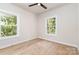 Bright bedroom with hardwood floors, two windows overlooking the landscaped yard, and a ceiling fan at 2512 Remington St, Charlotte, NC 28216
