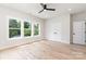 Bright bedroom featuring hardwood floors, white walls, three windows, and a closet space at 2512 Remington St, Charlotte, NC 28216