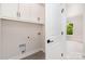 Laundry room featuring white cabinets, modern fixtures, and a view into the bedroom at 2512 Remington St, Charlotte, NC 28216