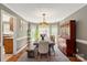 Sunlit dining room with a rustic wooden table, elegant chandelier, and ample space for Gathering gatherings at 2532 Annecy Dr, Matthews, NC 28105