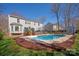 A beautiful in-ground pool with lounge chairs sits in a backyard surrounded by grass, trees, and a home with a deck at 2532 Annecy Dr, Matthews, NC 28105