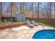 Lounge chairs sit next to a shed in a fenced-in yard near an in-ground pool surrounded by tall, bare trees at 2532 Annecy Dr, Matthews, NC 28105
