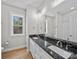 Neutral bathroom featuring hardwood floors, double vanity with black marble countertop, and a window letting in natural light at 297 Barr Link Rd, Mount Pleasant, NC 28124