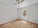 Neutral bedroom featuring hardwood floors, ceiling fan and a window letting in natural light and view to the exterior at 297 Barr Link Rd, Mount Pleasant, NC 28124