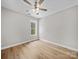 Neutral bedroom featuring hardwood floors, ceiling fan and a window letting in natural light and view to the exterior at 297 Barr Link Rd, Mount Pleasant, NC 28124