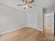 Neutral bedroom featuring hardwood floors, closet, ceiling fan and a window letting in natural light at 297 Barr Link Rd, Mount Pleasant, NC 28124