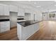 Kitchen island with granite countertops, white cabinets, hardwood floors and recessed lighting at 297 Barr Link Rd, Mount Pleasant, NC 28124