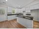 Modern kitchen featuring an island with granite countertops, white cabinets and hardwood floors at 297 Barr Link Rd, Mount Pleasant, NC 28124
