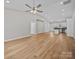 Open-concept living room with vaulted ceilings, modern fan, and hardwood floors flowing into the kitchen at 297 Barr Link Rd, Mount Pleasant, NC 28124