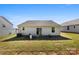 A cozy backyard view shows the home's exterior, a small patio set, and glimpses of neighboring houses at 3118 Maple Ridge Dr # 11, Gastonia, NC 28052