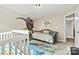 A playful Bedroom with a T-rex wall decal, a rug, a daybed, and a white crib at 3207 Oak Ridge Cir, Lincolnton, NC 28092