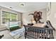 A bedroom with a crib, a twin bed and a large dinosaur mural at 3207 Oak Ridge Cir, Lincolnton, NC 28092