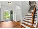 Bright foyer showcasing hardwood floors, a staircase with wooden banister, and a charming green front door at 3207 Oak Ridge Cir, Lincolnton, NC 28092