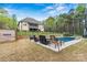 Backyard view of an in-ground pool with poolside furniture and lush landscaping at 3207 Oak Ridge Cir, Lincolnton, NC 28092