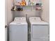 Functional laundry room with washer, dryer, shelving, and organized storage for efficient household tasks at 3524 Auburn Curb Rd, Charlotte, NC 28217